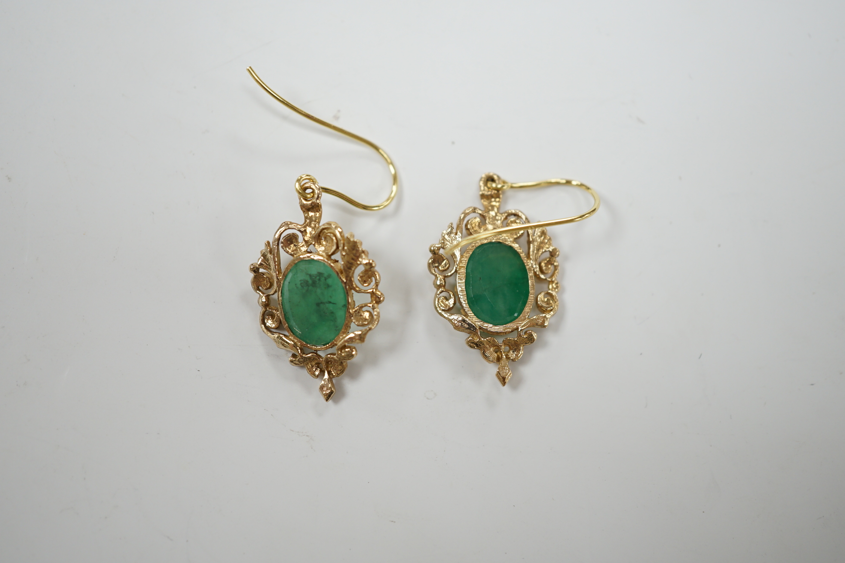 A pair of yellow metal and oval cut emerald set drop earrings, 23mm, gross weight 3.8 grams.